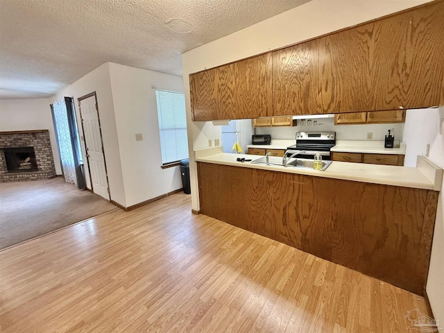 kitchen with light hardwood / wood-style flooring, stainless steel electric stove, a textured ceiling, and white fridge