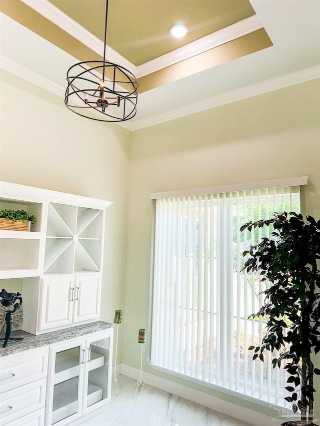 dining space with ornamental molding and a raised ceiling