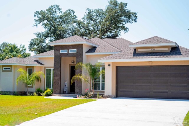 prairie-style home with a front lawn and a garage