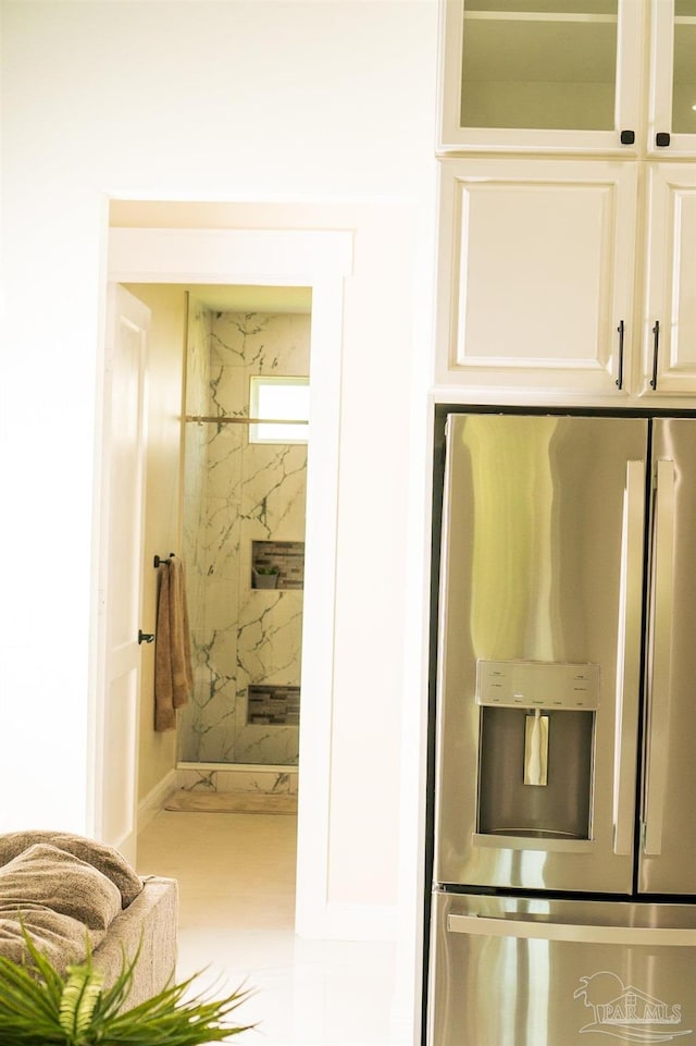 interior space with stainless steel fridge and white cabinets