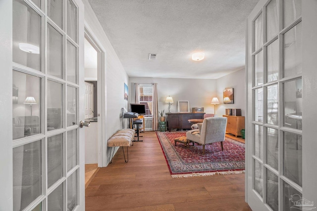 office space featuring a textured ceiling, french doors, and wood finished floors