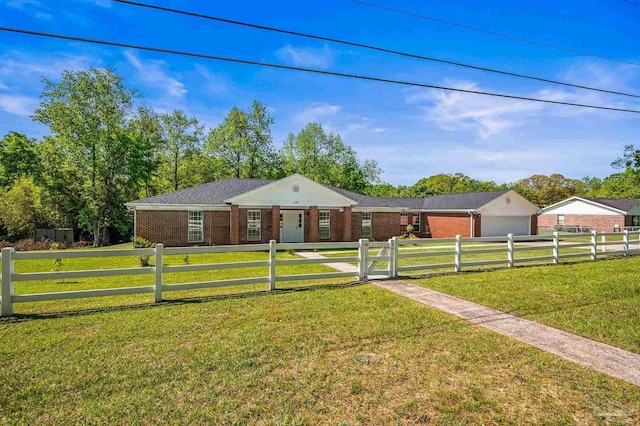 ranch-style home featuring a garage, brick siding, a front lawn, and a fenced front yard