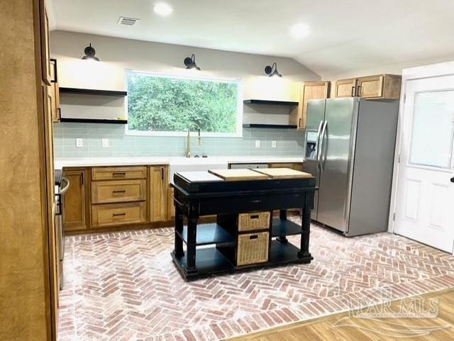 kitchen featuring open shelves, decorative backsplash, visible vents, and stainless steel fridge with ice dispenser