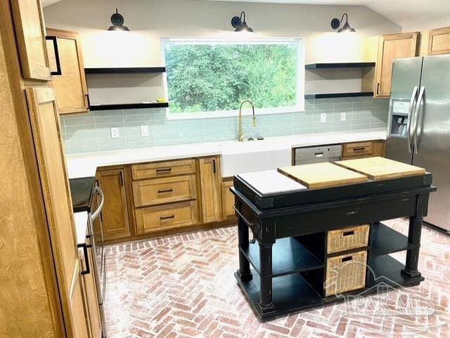 kitchen featuring open shelves, tasteful backsplash, light countertops, appliances with stainless steel finishes, and a sink