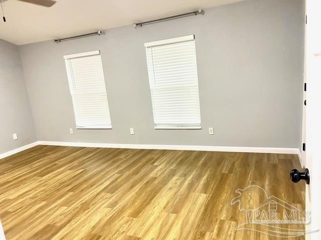 spare room featuring baseboards, a ceiling fan, and wood finished floors