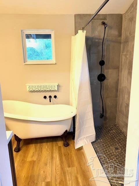 full bathroom featuring tiled shower, a soaking tub, and wood finished floors