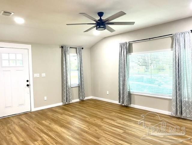 foyer featuring a ceiling fan, visible vents, baseboards, and wood finished floors