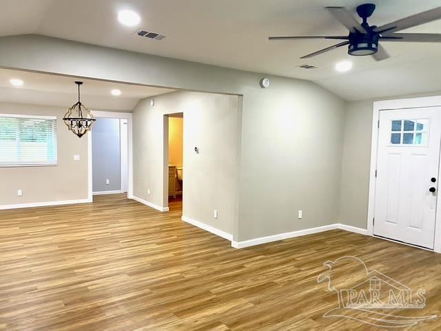 foyer entrance with lofted ceiling, recessed lighting, wood finished floors, baseboards, and ceiling fan with notable chandelier