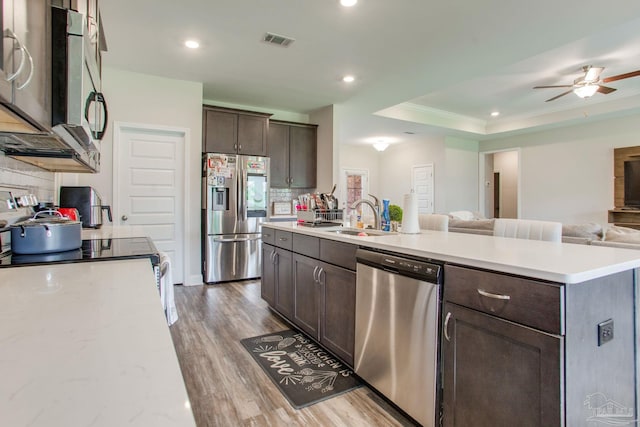 431 Broadleaf Cir, Cantonment, FL 32533 - kitchen with stainless steel appliances, a sink, open floor plan, dark brown cabinetry, and wood finished floors
