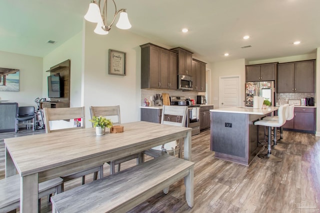 431 Broadleaf Cir, Cantonment, FL 32533 - kitchen with stainless steel appliances, a center island, backsplash, dark brown cabinetry, and recessed lighting