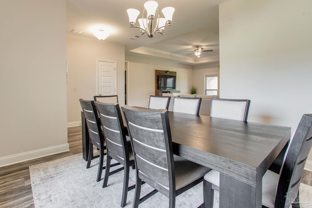 431 Broadleaf Cir, Cantonment, FL 32533 - dining area with a tray ceiling, wood finished floors, a chandelier, baseboards, and a ceiling fan