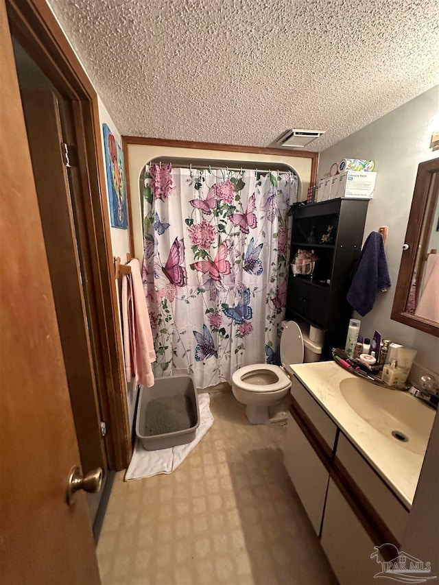 bathroom with vanity, toilet, a textured ceiling, and a shower with shower curtain