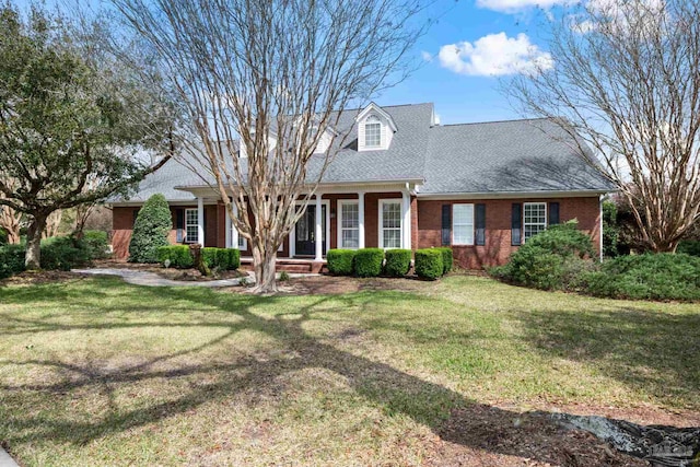 1788 Lorain Cir, Cantonment, FL 32533 - cape cod house with a front lawn, brick siding, a shingled roof, and covered porch