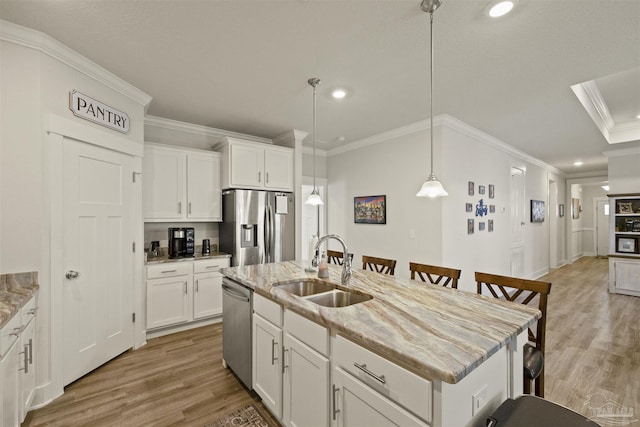 kitchen featuring sink, white cabinetry, stainless steel appliances, and a kitchen island with sink