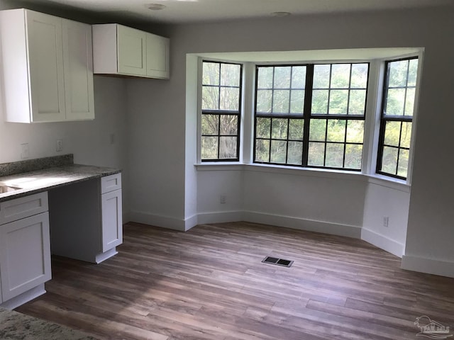 kitchen featuring stone countertops, white cabinets, and dark hardwood / wood-style floors