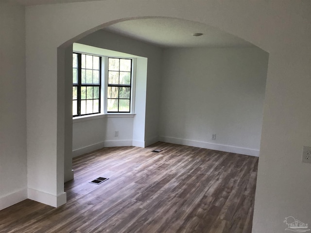 unfurnished room with dark hardwood / wood-style flooring