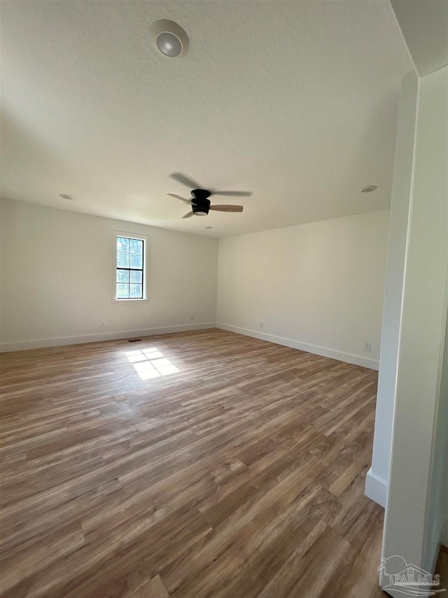 spare room with dark wood-type flooring and ceiling fan