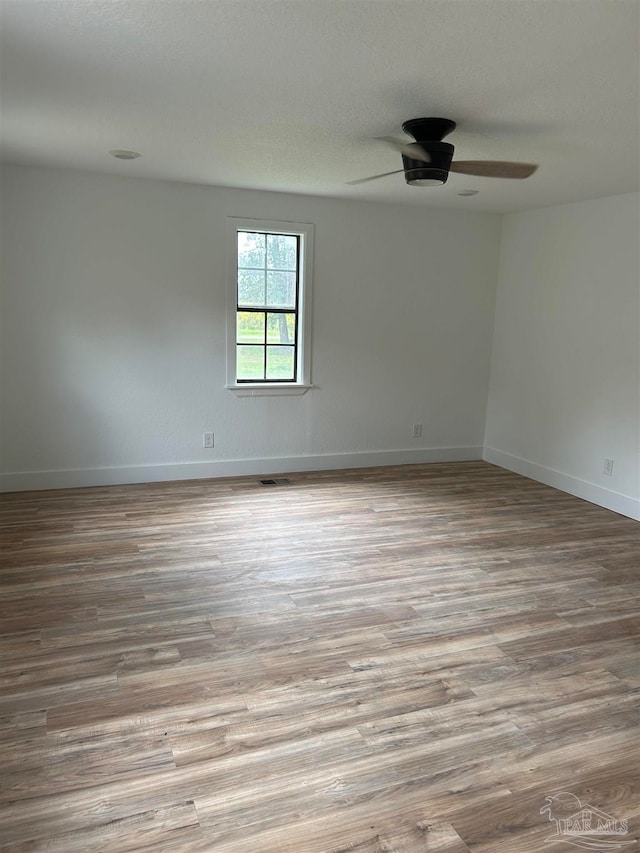 empty room featuring light hardwood / wood-style flooring and ceiling fan