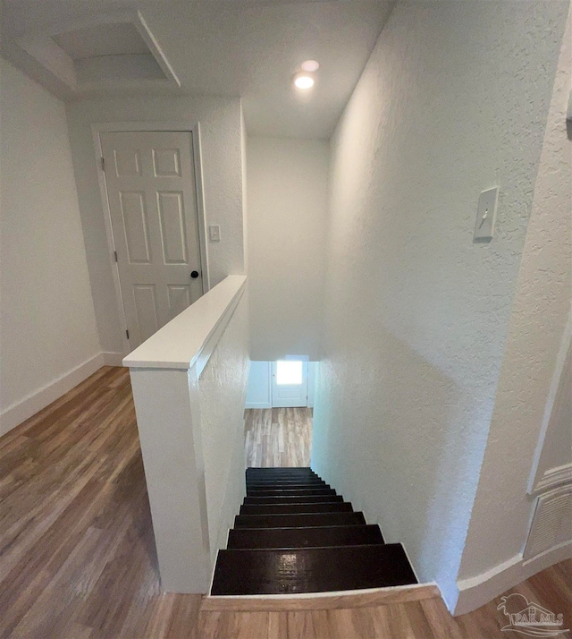 stairs featuring hardwood / wood-style floors