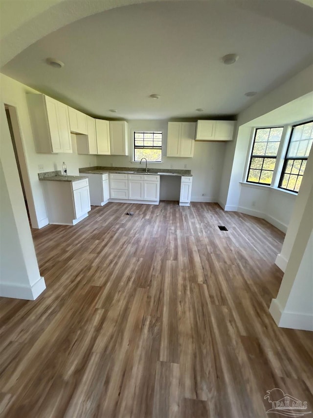 kitchen with sink, hardwood / wood-style floors, and white cabinets