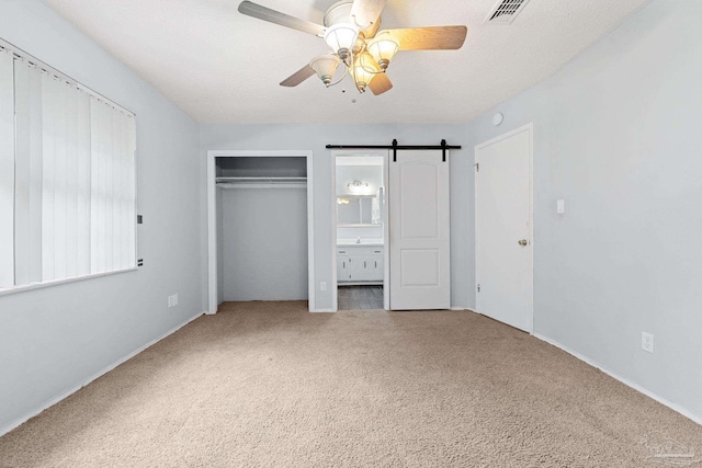7895 Bay Meadows Dr, Pensacola, FL 32507 - unfurnished bedroom with carpet floors, a barn door, a closet, and ceiling fan