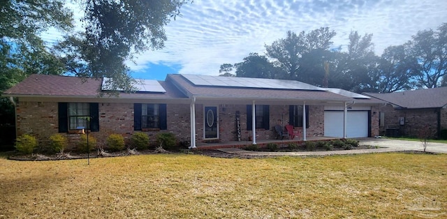 7895 Bay Meadows Dr, Pensacola, FL 32507 - ranch-style house featuring a porch, brick siding, a front lawn, a garage, and solar panels