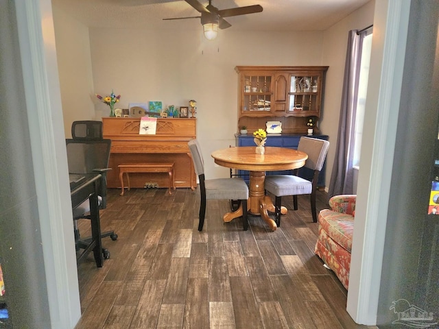 dining area with a ceiling fan and dark wood finished floors