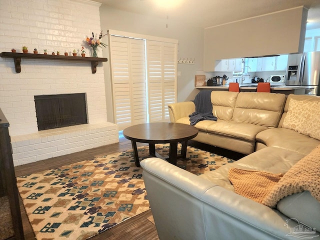 living area with dark wood-style flooring and a fireplace
