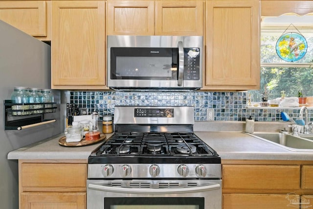 kitchen featuring appliances with stainless steel finishes, light brown cabinetry, and backsplash