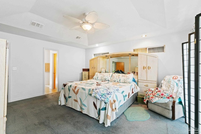 carpeted bedroom with ceiling fan and a raised ceiling