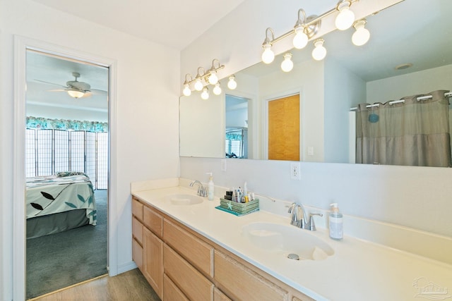 bathroom with dual vanity, wood-type flooring, and ceiling fan