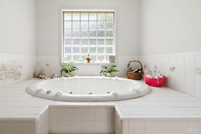 bathroom featuring tiled bath and a wealth of natural light