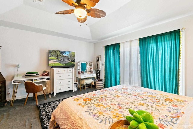 carpeted bedroom featuring a raised ceiling and ceiling fan