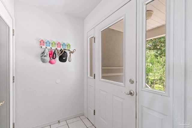 doorway to outside with light tile patterned flooring