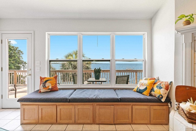 interior space featuring a water view and light tile patterned floors