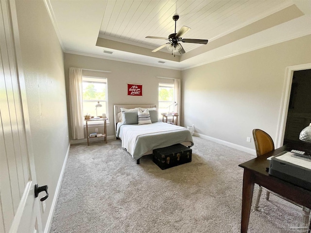 bedroom featuring baseboards, crown molding, a tray ceiling, and carpet