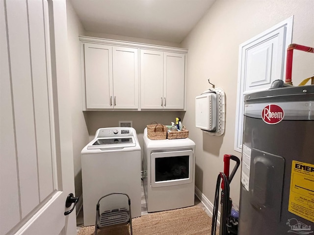 clothes washing area with washing machine and clothes dryer, baseboards, water heater, and cabinet space