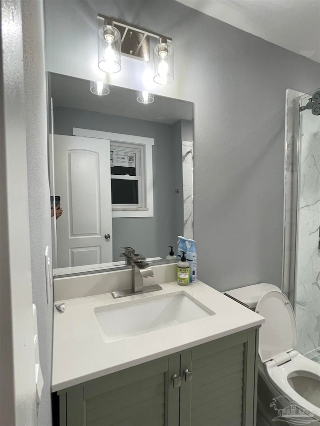 bathroom with vanity, toilet, and a tile shower