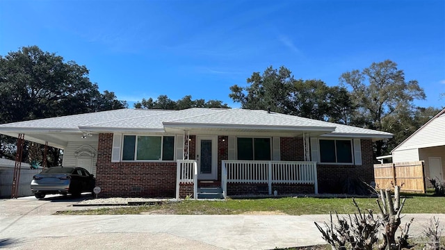 view of front of house with a porch, a front yard, and a carport