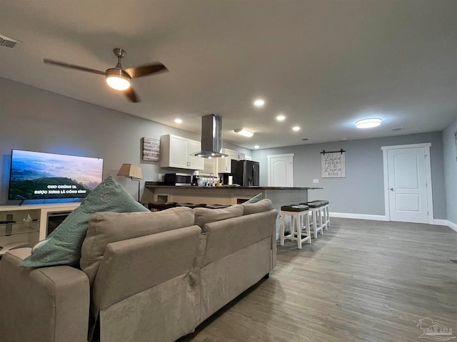 living room featuring ceiling fan and hardwood / wood-style flooring