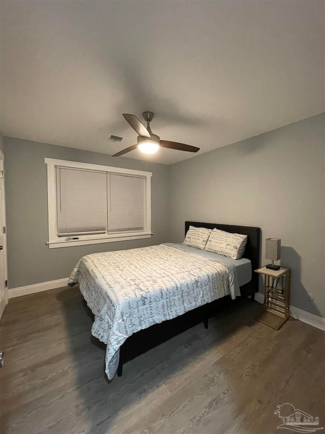 bedroom with dark hardwood / wood-style floors and ceiling fan