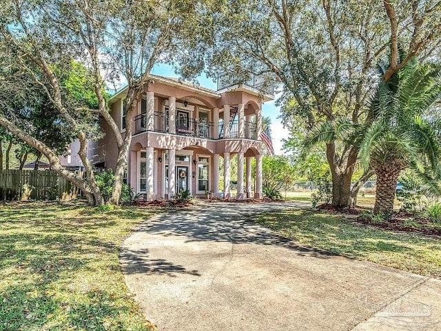 view of front of home with a balcony and a front yard