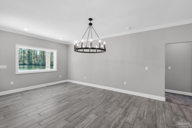 empty room with light hardwood / wood-style floors, crown molding, and an inviting chandelier