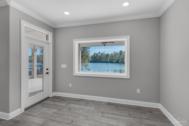 foyer entrance featuring crown molding, a healthy amount of sunlight, and light hardwood / wood-style floors