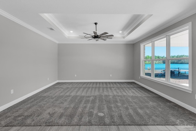 empty room featuring ceiling fan, crown molding, a water view, and hardwood / wood-style floors