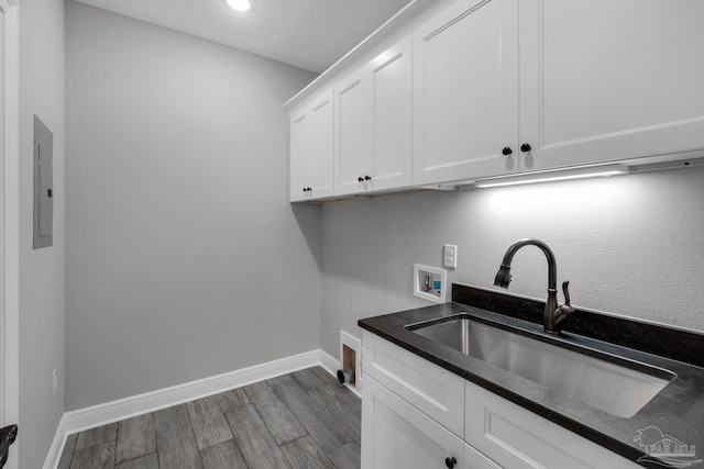 washroom with sink, cabinets, washer hookup, dark hardwood / wood-style floors, and electric panel