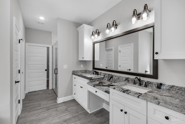 bathroom with vanity, wood-type flooring, and a shower with shower door