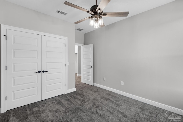 unfurnished bedroom with ceiling fan, dark carpet, and a closet