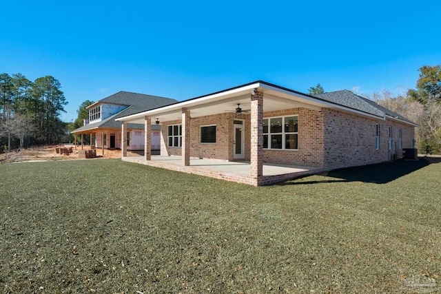 rear view of property featuring a lawn, ceiling fan, a patio area, and central air condition unit