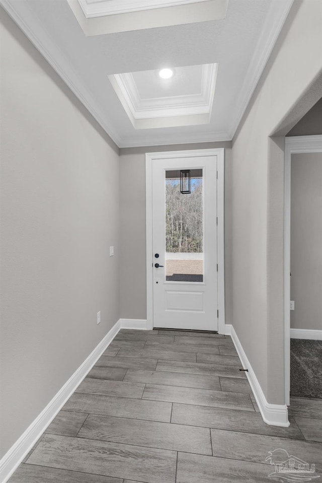 doorway featuring light wood-type flooring, ornamental molding, and a tray ceiling